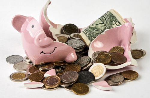 An image of a broken piggybank with coins and notes